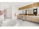 Bright bathroom with a soaking tub, double vanity, stylish mirror and elegant white and gold accents at 10752 Patina Hills Ct, Las Vegas, NV 89135