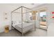 Inviting bedroom with a four-poster bed, soft lighting, and access to a private balcony at 10752 Patina Hills Ct, Las Vegas, NV 89135