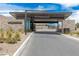 The Mesa Ridge community entrance features stone accents, desert plants, and an overhead clearance sign at 10752 Patina Hills Ct, Las Vegas, NV 89135