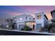 Contemporary home exterior showcasing clean lines, neutral color palette, and well-manicured landscaping under a beautiful sunset sky at 10752 Patina Hills Ct, Las Vegas, NV 89135