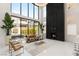 Spacious living room featuring a soaring fireplace, with large windows and bright, modern decor at 10752 Patina Hills Ct, Las Vegas, NV 89135