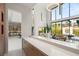 Bright living room boasts soaring ceilings, statement lighting and a large window wall overlooking the outside at 10752 Patina Hills Ct, Las Vegas, NV 89135
