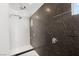 Contemporary shower featuring sleek fixtures, textured stone accent wall, and modern design elements at 10752 Patina Hills Ct, Las Vegas, NV 89135