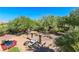 Aerial view of an outdoor backyard area featuring a comfortable lounge area, dining table, and lush landscaping at 1091 Casa Palermo Cir, Henderson, NV 89011