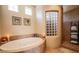 Elegant bathroom featuring a large jacuzzi tub, tiled walls, and natural light at 1091 Casa Palermo Cir, Henderson, NV 89011
