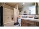 Well-lit bathroom featuring bathtub and shower combo, vanity with sink and tile backsplash, offering a relaxing space at 1091 Casa Palermo Cir, Henderson, NV 89011