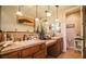 Well-lit bathroom features double sinks with tile countertops and a large mirror complemented by stylish pendant lighting at 1091 Casa Palermo Cir, Henderson, NV 89011