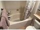 Bathroom featuring a soaking tub with a decorative shower curtain, plus toilet and sink at 1091 Casa Palermo Cir, Henderson, NV 89011