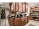 Kitchen island with dark countertops, wood cabinetry, and stainless steel appliances at 1091 Casa Palermo Cir, Henderson, NV 89011