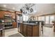 Modern kitchen with stainless steel appliances, wooden cabinetry, and a view into the living area at 1091 Casa Palermo Cir, Henderson, NV 89011