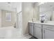Modern bathroom with white tile, shower, and gray vanity, providing a clean and stylish design at 10933 Sageview Ave, Las Vegas, NV 89166