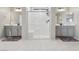Bright bathroom with double sinks, gray cabinets, and glass-enclosed shower with a bench at 10933 Sageview Ave, Las Vegas, NV 89166