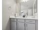 Bathroom vanity with gray cabinets, quartz countertop, and large mirror, offering functionality and style at 10933 Sageview Ave, Las Vegas, NV 89166