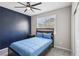 Stylish bedroom features an accent wall, ceiling fan, and window for natural light at 10933 Sageview Ave, Las Vegas, NV 89166