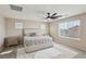 Spacious bedroom with a ceiling fan, carpeted floor, and multiple windows at 10933 Sageview Ave, Las Vegas, NV 89166
