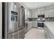 Spacious kitchen with stainless steel appliances, gray cabinets and tile backsplash at 10933 Sageview Ave, Las Vegas, NV 89166