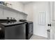 Laundry room featuring a modern washer and dryer set with shelving and a tile floor at 10933 Sageview Ave, Las Vegas, NV 89166