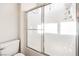 Bathroom featuring a toilet, shower, and artistic sliding shower door at 1563 Cattle Ranch Pl, Henderson, NV 89002