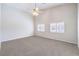 Bedroom featuring plush carpet, two windows with plantation shutters, and a ceiling fan for added comfort at 1563 Cattle Ranch Pl, Henderson, NV 89002