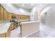 Well-lit kitchen with light wood cabinets, stainless steel appliances, and a breakfast bar for casual dining at 1563 Cattle Ranch Pl, Henderson, NV 89002