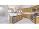 Open kitchen featuring stainless steel appliances, light wood cabinets, and a breakfast bar overlooking the living area at 1563 Cattle Ranch Pl, Henderson, NV 89002