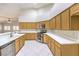 Bright kitchen features light wood cabinetry, stainless steel appliances, white countertops, and white tile flooring at 1563 Cattle Ranch Pl, Henderson, NV 89002