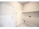 Clean laundry room features tile flooring, utility sink, and convenient access door to the home at 1563 Cattle Ranch Pl, Henderson, NV 89002