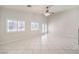 Bright living room with tile flooring, plantation shutters, ceiling fan, and access to the backyard patio through French doors at 1563 Cattle Ranch Pl, Henderson, NV 89002