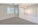 Open living space with carpeted area, a double door entryway, and white-tiled flooring that leads into a hallway at 1563 Cattle Ranch Pl, Henderson, NV 89002