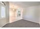 Inviting living room with gray carpet, a hanging light fixture, and an arched window for natural light at 1563 Cattle Ranch Pl, Henderson, NV 89002