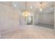 Spacious living room with tile flooring, a decorative chandelier, and a carpeted area in the background at 1563 Cattle Ranch Pl, Henderson, NV 89002