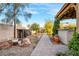 Serene backyard featuring a brick pathway, landscaping, and a covered outdoor kitchen area at 197 Ebb Tide Cir, Las Vegas, NV 89123