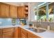 Bright kitchen featuring stainless steel sink, wood cabinets, and tiled backsplash at 197 Ebb Tide Cir, Las Vegas, NV 89123