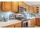 Bright kitchen with tiled backsplash, wood cabinets, and stainless steel appliances at 197 Ebb Tide Cir, Las Vegas, NV 89123