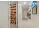 Walk-in pantry with lots of storage shelves, adjacent to hallway with hanging pots and pans at 197 Ebb Tide Cir, Las Vegas, NV 89123