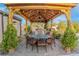 Charming outdoor patio with a wooden pergola, dining set, and lush landscaping at 197 Ebb Tide Cir, Las Vegas, NV 89123