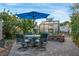 The patio has a dining table under a blue umbrella and a greenhouse in the background at 197 Ebb Tide Cir, Las Vegas, NV 89123