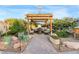 Charming backyard pergola with comfortable seating around a fire pit, surrounded by lush landscaping at 197 Ebb Tide Cir, Las Vegas, NV 89123