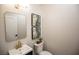 Stylish powder room featuring a vanity with brass fixtures, decorative art, and modern toilet at 2099 Mountain City St, Henderson, NV 89052