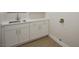 Well-lit laundry area with modern cabinets, marble countertop, and stainless-steel sink at 2099 Mountain City St, Henderson, NV 89052