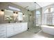Luxurious main bathroom with dual sinks, a glass shower, and a soaking tub at 2099 Mountain City St, Henderson, NV 89052