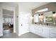Elegant main bathroom featuring a dual sink vanity, tile accent wall, and doorway to the bedroom at 2099 Mountain City St, Henderson, NV 89052