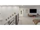 Bright, open hallway with decoratively framed Gathering photos ascending the staircase and a spacious seating area with a television at 2240 Boutique Ave, Henderson, NV 89044