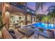 Evening shot of a luxury pool with a built-in lounge area and outdoor seating with views into the home at 2240 Boutique Ave, Henderson, NV 89044