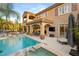 Beautiful backyard features a pool, spa, covered patio, outdoor tv, and mature tropical landscaping at 2240 Boutique Ave, Henderson, NV 89044