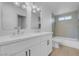 Updated bathroom with modern lighting, double sink vanity, and tub with shower at 2801 Emmons Ave, North Las Vegas, NV 89030
