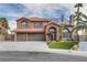 Charming two-story home featuring a stone facade, three-car garage, arched entryway, and desert landscaping at 3924 Diamond Ridge St, Las Vegas, NV 89129