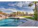 Inviting backyard pool with rock features, artificial grass, palm trees, and a privacy wall at 3924 Diamond Ridge St, Las Vegas, NV 89129