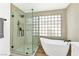 Stylish bathroom showcasing frameless glass shower and freestanding tub by a window at 4117 Sinew Ct, Las Vegas, NV 89129