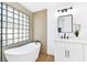Elegant bathroom featuring a soaking tub, glass block window and modern vanity at 4117 Sinew Ct, Las Vegas, NV 89129